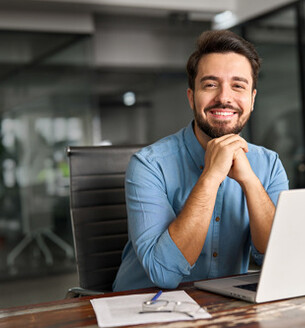 Lachende man poseert vanachter laptop