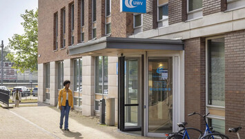 Vrouw in gele jas bij UWV-kantoor