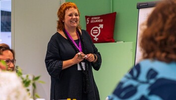 Lachende vrouw voor een groep mensen