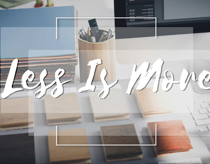 Op een bureau uitgelegde objecten met over plaatje geschreven tekst "Less is more"